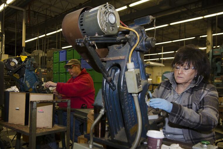 Jason Blake, left and Cathy Spehar, Zippo Manufacturing Co. employees, trim brass lighter cases at the company’s plant in Bradford, Pa. Zippo is the top employer in rural McKean County.