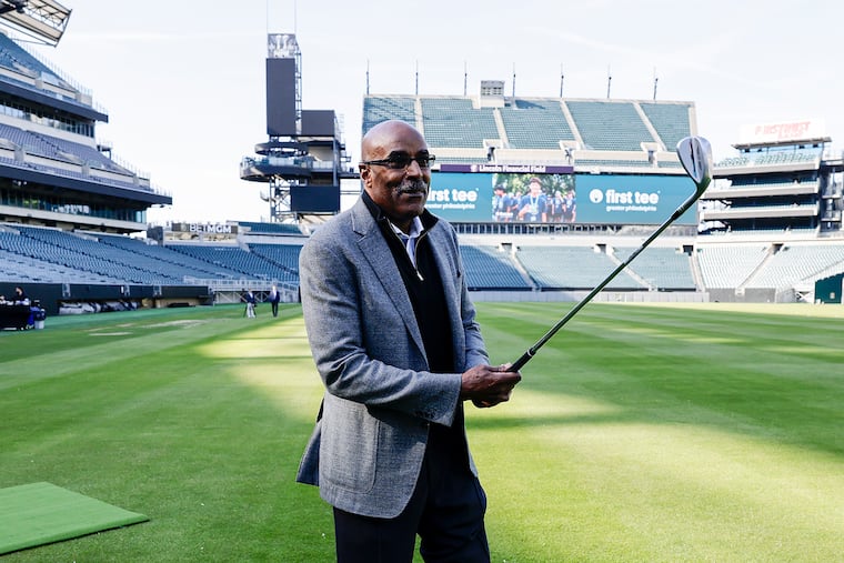 Former Eagles wide receiver turned radio commentator Mike Quick holds a golf club during First Tee's
"Links at the Linc" event on Thursday.