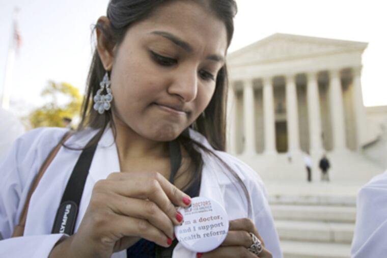 Dr. Sonia Nagda puts on a pin supporting the health care reform law
signed by President Obama as she gathers with other health care
professionals in front of the Supreme Court in Washington, Monday,
March 26, 2012, as the court begins three days of arguments on the
health care. (AP Photo/Charles Dharapak)