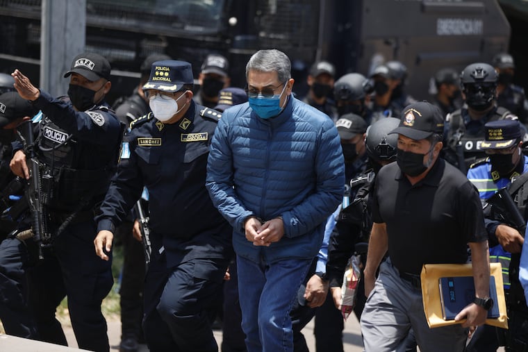 Police officers escort Juan Orlando Hernández to an airplane in Tegucigalpa, Honduras, for extradition to the United States in 2022.