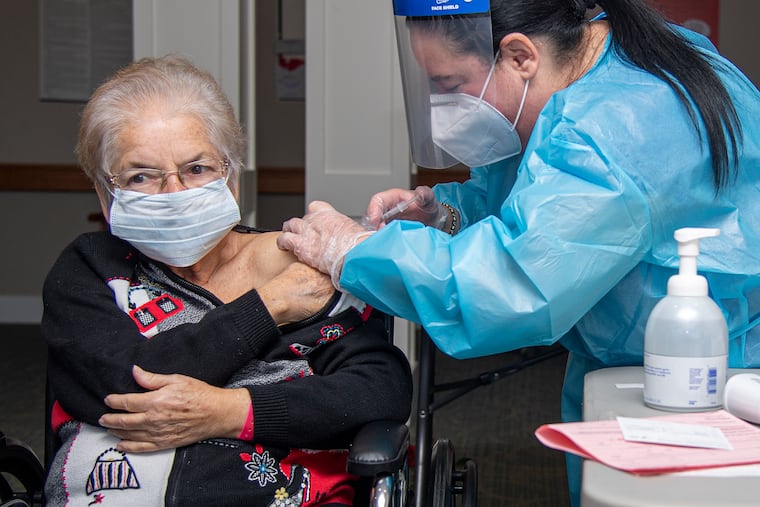 Pharmacist, Nadine M. Mackey (right) injects the COVID-19 vaccine to nursing home resident Lydu Trudeau at the Power Back Rehabilitation in Phoenixville last month.