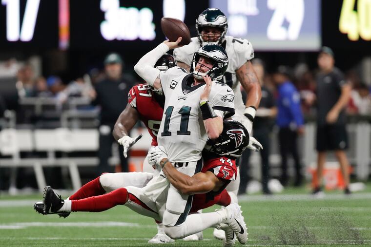 Eagles quarterback Carson Wentz gets rid of the football past Atlanta Falcons linebacker Vic Beasley during the fourth-quarter on Sunday, September 15, 2019 in Atlanta.