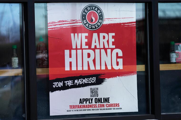 A hiring sign is displayed at a restaurant in Rolling Meadows, Ill. America’s employers added a robust 517,000 jobs in January, a surprisingly strong gain in the face of the Federal Reserve’s aggressive drive to slow growth and tame inflation with higher interest rates.
