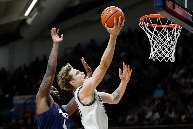 Villanova forward Matt Hodge lays up the basketball past Duquesne's John Hugley at the Finneran Pavilion on Saturday.