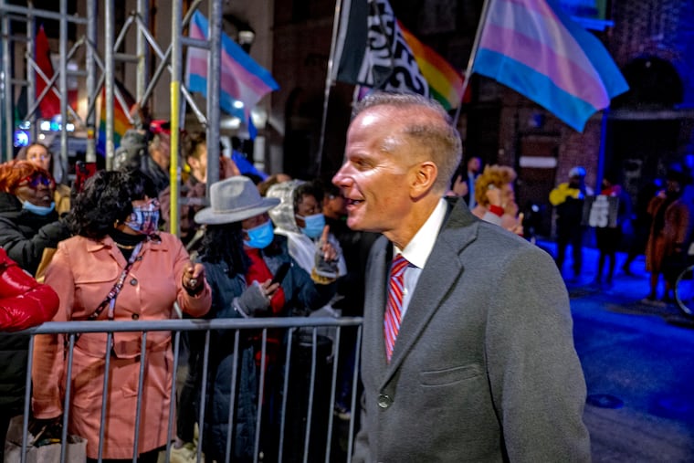 Former U.S. attorney Bill McSwain passes protesters outside the Union League of Philadelphia Jan. 24 as he arrives for an event honoring Florida Gov. Ron DeSantis.