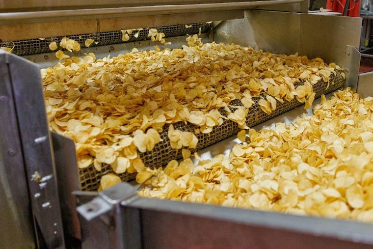 Utz potato chips move through a conveyor belt at the company's factory in Hanover, York County.