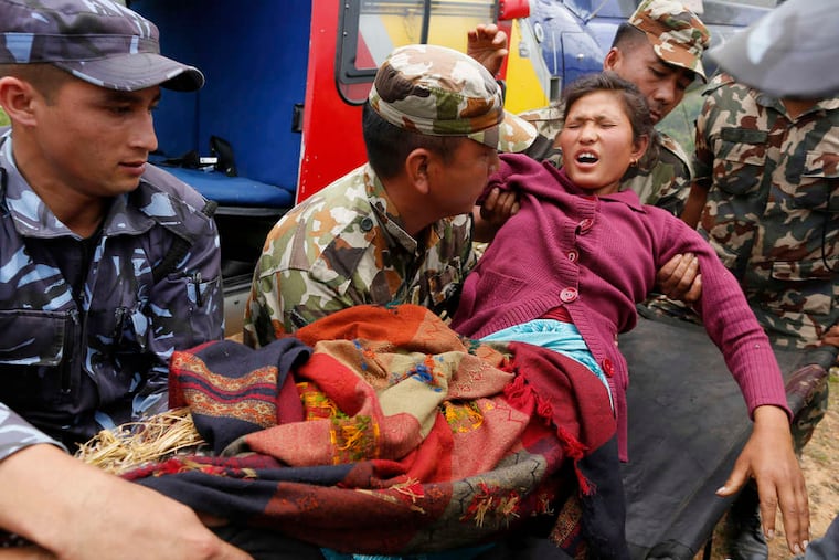 Sita Karka, suffering two broken legs from Saturday's massive quake, arrives by helicopter from the heavily damaged Ranachour village in Nepal. More than 4,700 are dead, at least 8,000 injured.