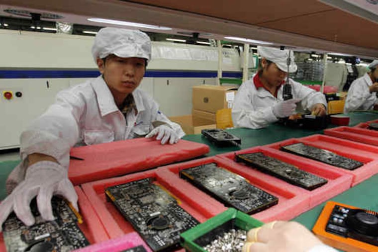 Staff members work on the production line at the Foxconn complex where iPhones and Dell computers are made. The chairman spoke with reporters about the number of suicides.
