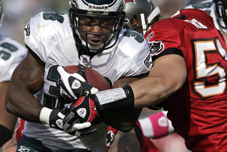 Brian Westbrook fights off a tackle by the Buccaneers' Barrett Ruud on his way into the endzone on Sunday. (David Maialetti / Staff Photographer)