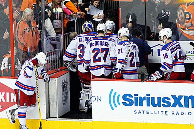 The Rangers' Martin St. Louis hangs his head as his teammates head off the bench to the locker room. (Chris Szagola/AP)