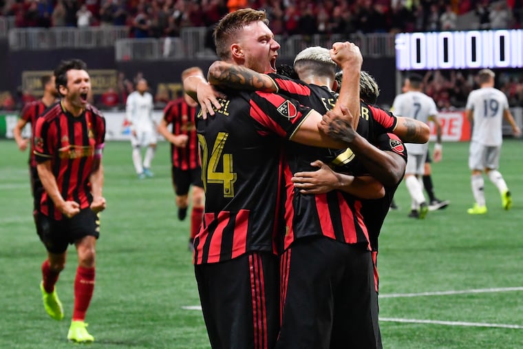 Atlanta United's Julian Gressel (24) embraces teammate Franco Escobar after Escobar scored against the New England Revolution.