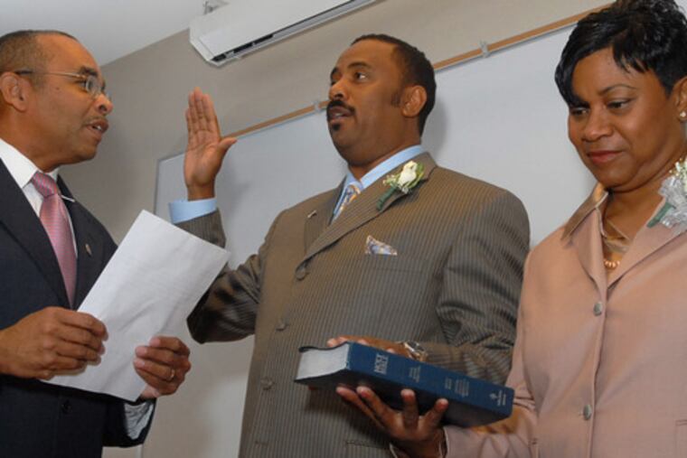 Lorenzo Langford is sworn in as Atlantic City mayor by Council President William Marsh. Nynell Langford holds the Bible for her husband, who also led the city from 2002 to 2005.