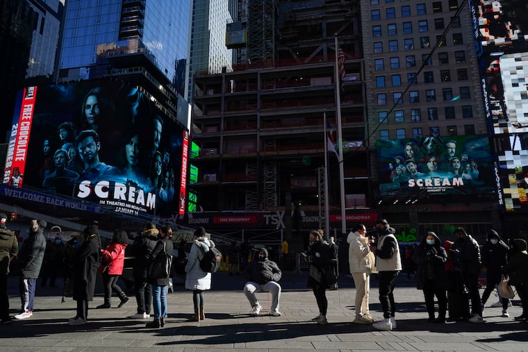 People wait in a long line to get tested for COVID-19 in Times Square on Monday,
