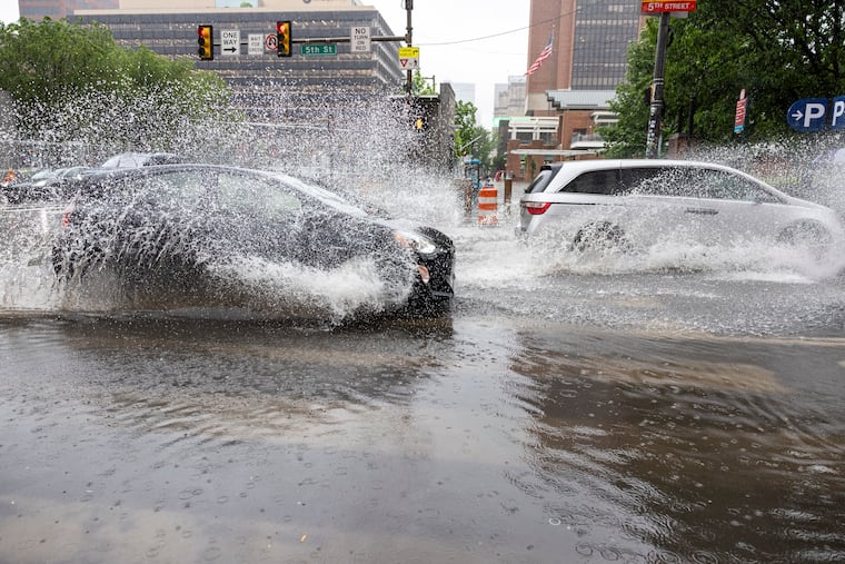 Cars drive through the flooded streets at Fifth and Market Streets in Center City in May. Climate change and an old sewer system threaten the city, writes Nathan Boon.