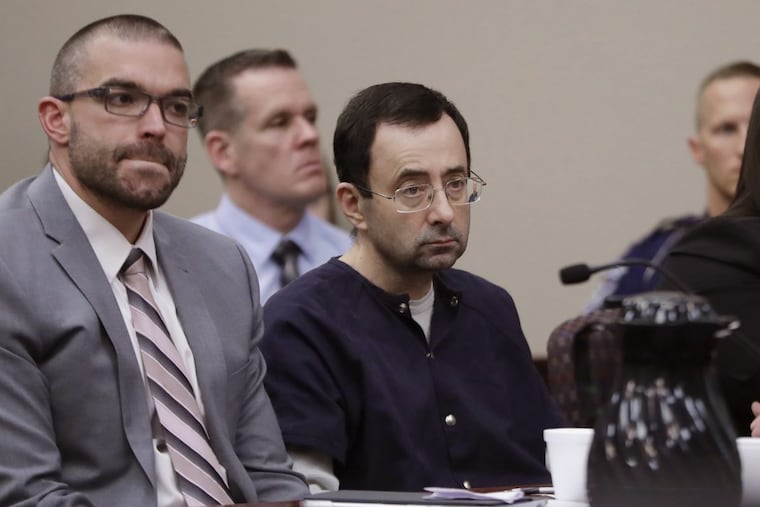 Larry Nassar sits with attorney Matt Newburg during his sentencing hearing Wednesday, Jan. 24, 2018, in Lansing, Mich. The former sports doctor who admitted molesting some of the nation's top gymnasts for years was sentenced Wednesday to 40 to 175 years in prison as the judge declared: "I just signed your death warrant." The sentence capped a remarkable seven-day hearing in which scores of Nassar's victims were able to confront him face to face in the Michigan courtroom.