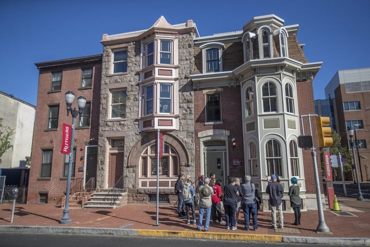 The tour of Cooper Street stops in front of the 400 block of Cooper to look at homes that are now part of Rutgers University.