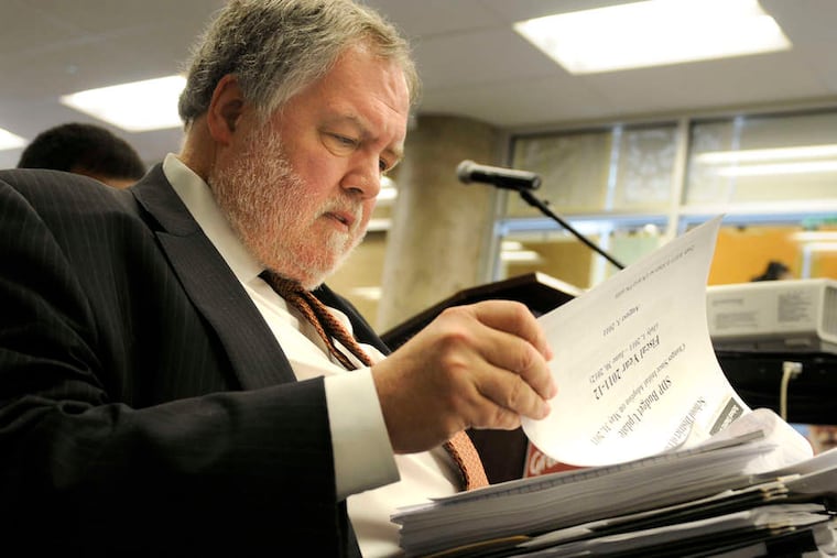 In this file photo, Mr. Masch, as the Philadelphia School District's chief financial officer, goes over paperwork at a public meeting in 2011.