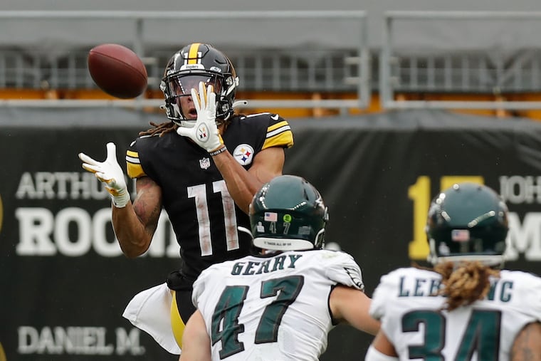 Steelers wide receiver Chase Claypool watches the football into his hands as Eagles linebacker Nate Gerry and cornerback Cre'von LeBlanc watch Claypool score a 35-yard touchdown to seal the victory.