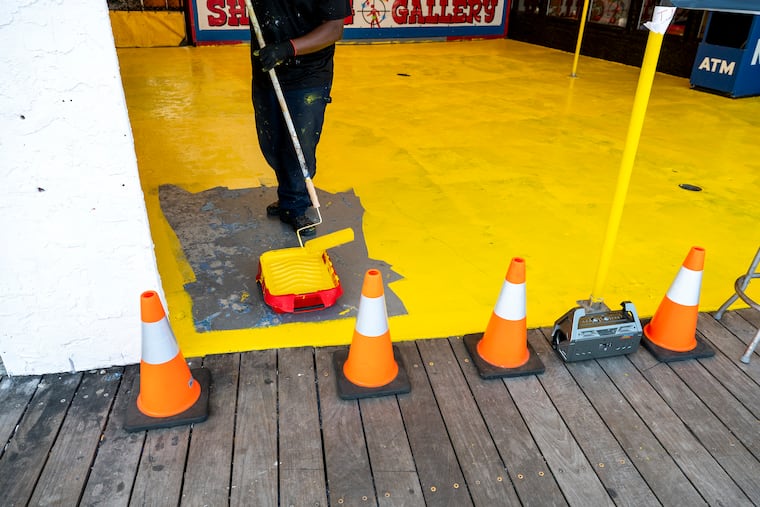 An arcade game on the boardwalk in Wildwood gets freshened up with some paint ahead of the summer season at the Jersey Shore. Scene Through the Lens runs every Monday on page B-2. There is a template in Roxen. This sentence runs at the top of the photo: More of photographer Tom Gralish’s visual exploration of our region can be seen in his blog at Inquirer.com/sceneontheroad.