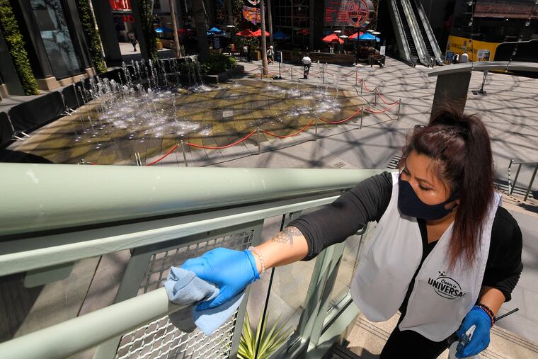 Andrea Castaneda cleans the railings at Universal CityWalk near Universal City, Calif.