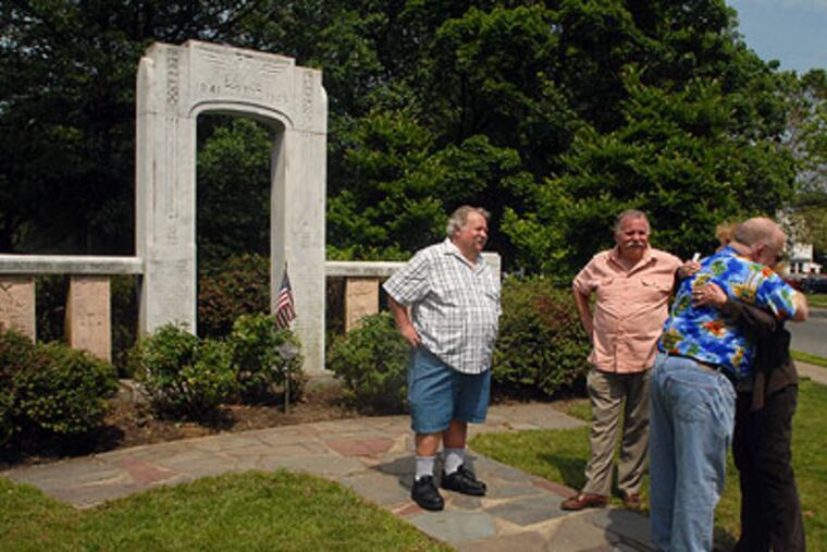 Phil Cohen embraces Florence Mitchell as they leave after meeting with brothers Paul Huber and Randall Huber to view the name of 1st Lt. Charles Adams on the WWII Memorial in Knight Park in Collingswood. (Tom Gralish / Staff Photographer)