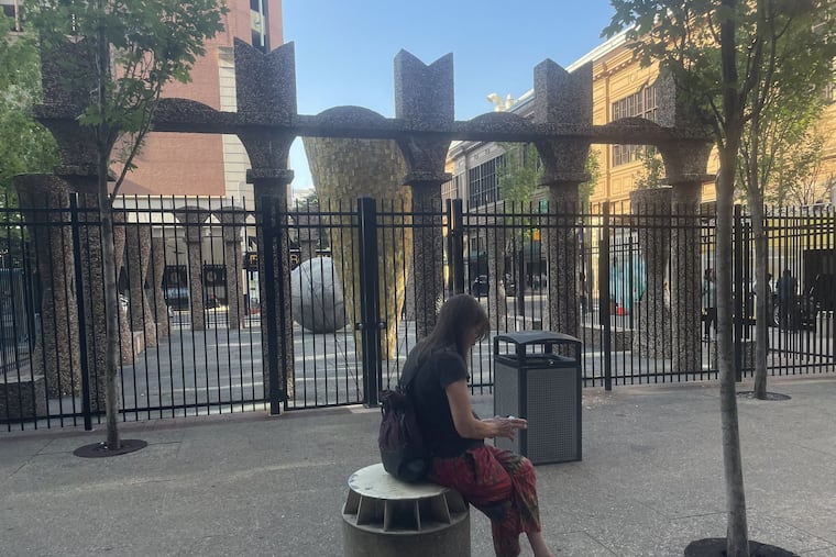 Since the Marriott Hotel fenced off "World Park," the sculpture and public space at 12th and Filbert Streets, tourists and Reading Terminal Market customers are unable to access the space or use its benches to rest. This woman sits on a bollard near the hotel's driveway.