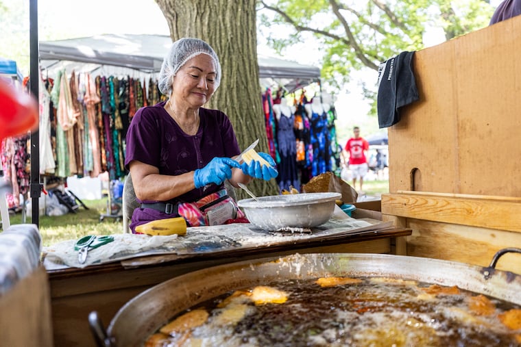 On Luu, of Southwest Philadelphia, cuts bananas to be fried at the Southeast Asian Market in FDR Park, in Philadelphia, on Saturday, May, 25, 2024.