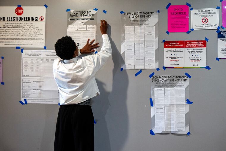 Poll worker Janice Masud-Paul attaches a notice to a board at the Cherry Hill Districts 1 and 25 voting place in the Erlton Fire House on Rt. 70 on Election Day in November.