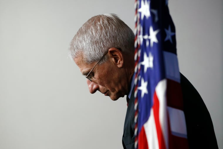 Dr. Anthony Fauci, director of the National Institute of Allergy and Infectious Diseases, listens as President Donald Trump speaks during a coronavirus task force briefing at the White House in Washington.
