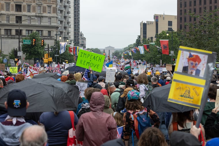 Crowds of people gather at the “No Kings” protest march toward the Philadelphia Museum of Art on Saturday. A Malvern man was arrested a similar protest in West Chester for carrying a gun without a license, police say.