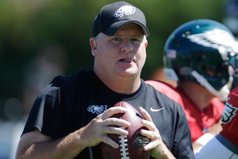 Chip Kelly and quarterback Michael Vick throws a passes during NFL football practice at the team's training facility, Wednesday, Sept. 4, 2013, in Philadelphia. (Matt Rourke/AP)