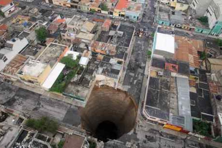A huge sinkhole covers an intersection in Guatemala City. Authorities estimate the hole is 66 feet wide and nearly 100 feet deep.