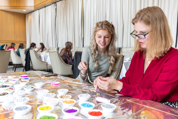 Jenna Collazzo, 25, of Center City, Pa., and her mom Lisa Collazzo, 57, of Media, Pa., are making friendship bracelets together at the Taylor Swift Galentine’s Tea Blending event in Philadelphia, Pa., on Saturday, Feb. 10, 2024.