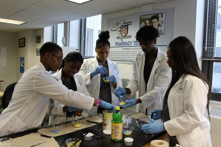 Philadelphia Job Corps pharmacy tech students, Alana Miller, left to right, Princess Wimberly, Kiara Mackie, Daniel Bierre and Achante Holmes mix ingredients to make a face mask, using similar techniques to what is done in a pharmacy. Job Corps is partnering with CVS and Kensington Health Sciences Academy to create a pharmacy technician apprenticeship program