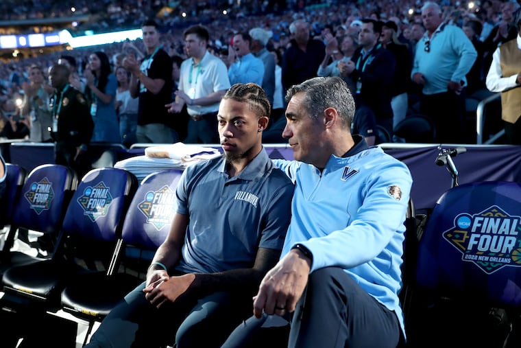 Coach Jay Wright, right, sitting with Justin Moore during player introductions Saturday.