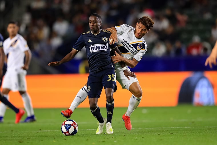 Philadelphia Union midfielder Jamiro Monteiro holds off Los Angeles Galaxy midfiedler Jonathan dos Santos during the Galaxy's 2-0 win at Dignity Health Sports Park in Carson, Calif.