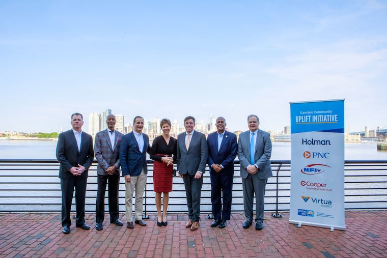 Organizers of the Camden Community Uplift Initiative on the Camden waterfront (from left): Kevin O'Dowd, co-CEO, Cooper University Health; Dennis Pullin, CEO, Virtua Health; Steve Grabell, CFO, NFI; Mindy Holman, chair, Holman; Bill Golderer, CEO, United Way; Camden Mayor Vic Carstarphen; and Joe Meterchick, regional president, PNC.