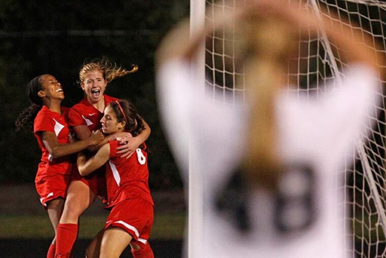 Neshaminy's Gabby Farrell, left and Megan Schafer,center, hug Amy Mandia after Mandia winning goal in OT. (Ron Cortes/Staff Photographer)