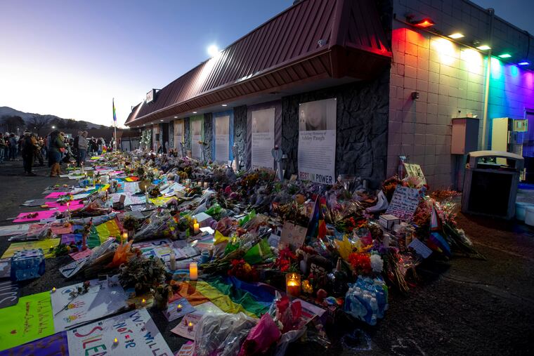 Mourners gather outside Club Q to visit a memorial, which has been moved from a sidewalk outside of police tape that was surrounding the club, on Nov. 25 in Colorado Spring, Colo.