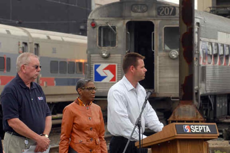 Jim Fox, director of system security for SEPTA, speaks at a news conference at the agency's Wayne facility. With him are James B. Jordan (left) and Frances Jones, assistant general managers for SEPTA. At right is a rooftop pantograph of the sort involved.