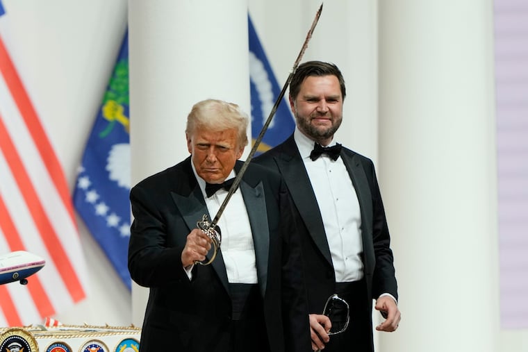President Donald Trump holds a saber after using it to cut a cake, as Vice President JD Vance looks on, at the Commander in Chief Ball, part of the 60th Presidential Inauguration, on Monday.