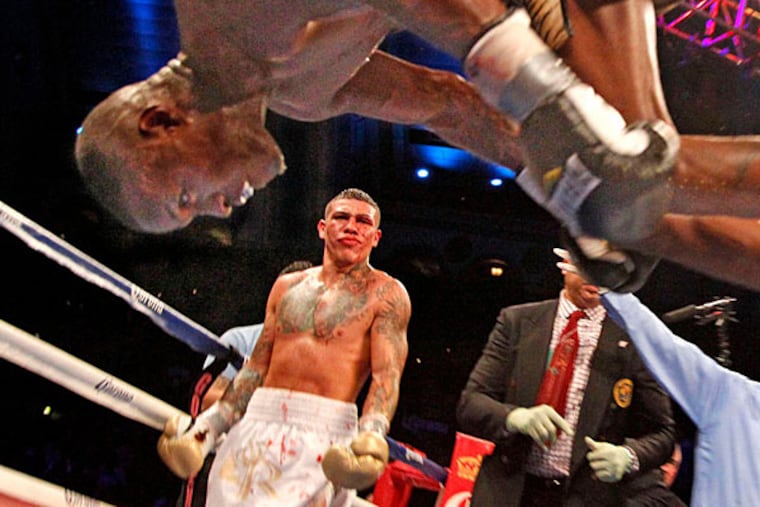 Peter Quillin does a flip as a disappointed Philadelphia fighter Gabe Rosado looks on after their middleweight title fight was stopped in the 10th round due to a cut on Rosado, at Boardwalk Hall in Atlantic City on October 26, 2013. (Ron Cortes/Staff Photographer)