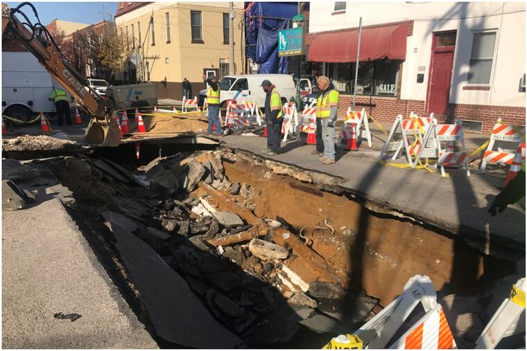 Crews work at the sinkhole where a water main broke at Dickinson and 12th Street in South Philadelphia.