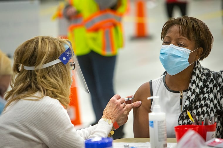Cornelia Lavong, Vice President of Clinical Operations and Chief of Nursing with Red Lion Home Healthcare gets vaccinated by Pat DeHorsey. Medical staff and volunteers give COVID-19 vaccinations at Montgomery County Community College on Jan. 6.
