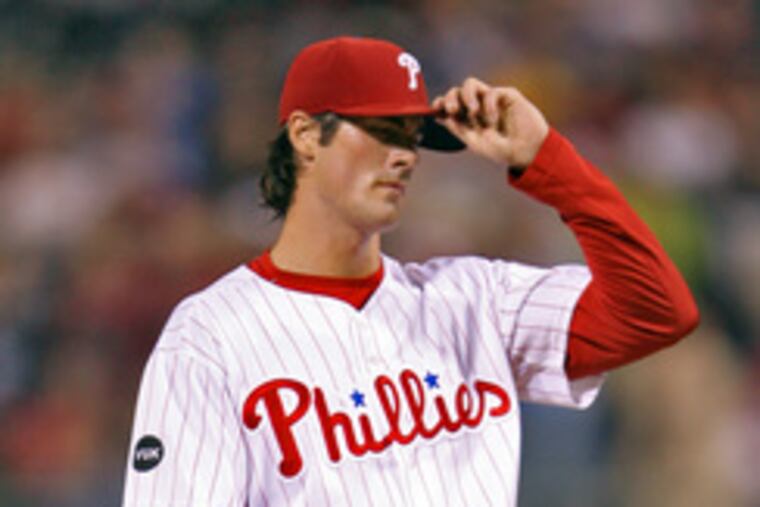 Cole Hamels, who no-hit Brewers for six innings, adjusts cap after allowing 2-run homer in seventh.