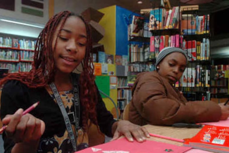 Sinefah Hewett (left), 10, and Tierra McClennan, 12, make Valentine's Day cards at the Charles L. Durham branch in West Philly.