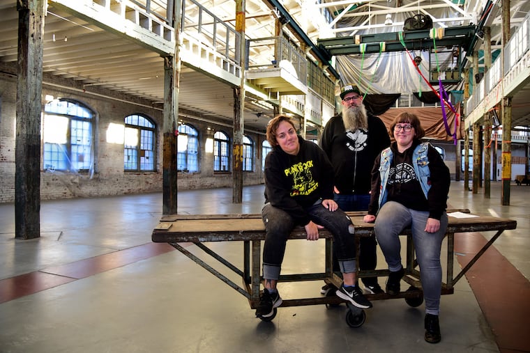 Joe Kuzemka (center) poses with co-mangers Adrienne Hart (left) and Sara Casey (right) inside the Robeling Wireworks October 17, 2018. This weekend it will be the site of the Halloween-themed Trenton Punk Rock Flea Market.