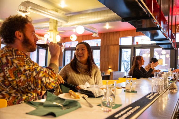 Coworkers Katie Lee, of Fairmount, Pa., and Jeffrey Werner, of West Philadelphia, are enjoying drinks and food at the bar at Manong in Philadelphia, Pa., on Thursday, March. 5, 2026.