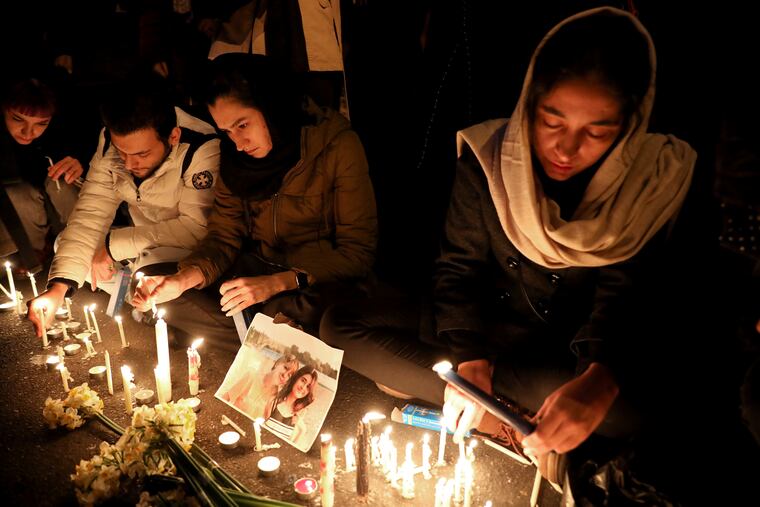 People gather for a candlelight vigil to remember the victims of the Ukraine plane crash, at the gate of Amri Kabir University that some of the victims of the crash were former students of, in Tehran, Iran, Saturday, Jan. 11, 2020. Iran on Saturday, Jan. 11, acknowledged that its armed forces "unintentionally" shot down the Ukrainian jetliner that crashed earlier this week, killing all 176 aboard, after the government had repeatedly denied Western accusations that it was responsible. (AP Photo/Ebrahim Noroozi)