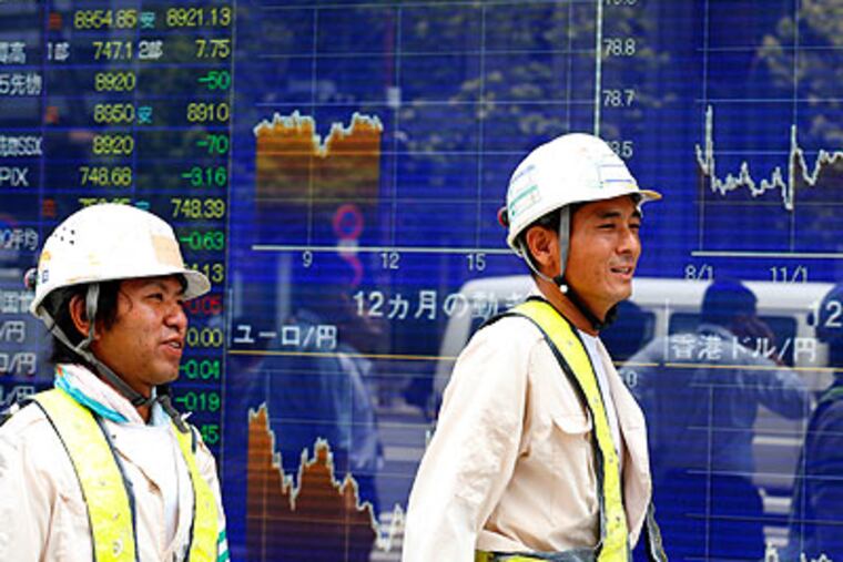 Workers walk past an electronic stock indicator in Tokyo, Friday, Aug. 10, 2012. Asian stock markets floundered Friday, as traders displayed caution ahead of the release of trade data from China. Japan's Nikkei 225 index fell 0.6 percent to 8,924.82. (AP Photo / Shizuo Kambayashi)